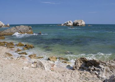 Scenic rocky beach with waves crashing against rocks.