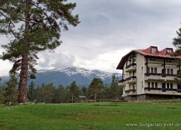 A spacious house with a majestic mountain in the backdrop.