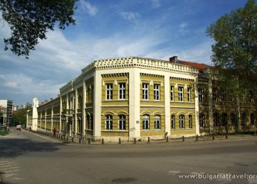 Yellow building with white trim against blue sky.